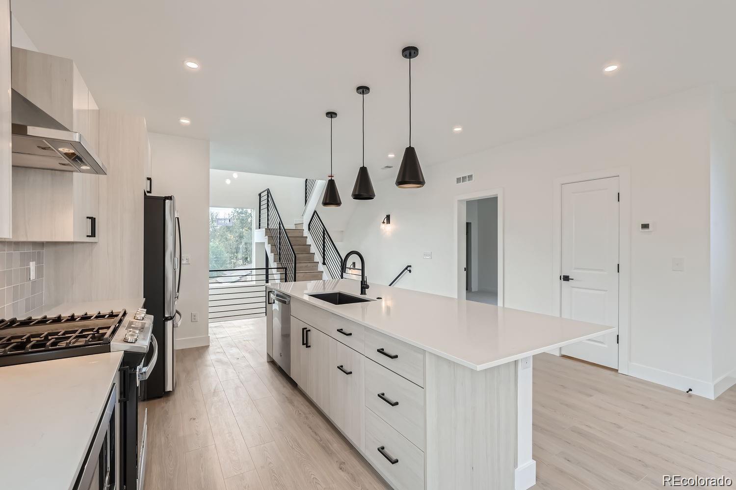 a kitchen with stainless steel appliances kitchen island a refrigerator and a sink