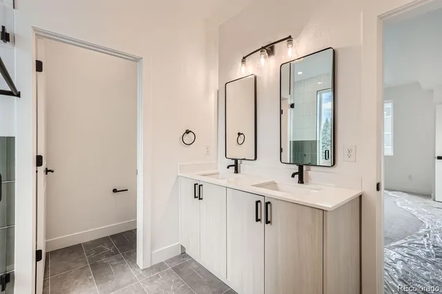 a bathroom with double vanity sink and a mirror