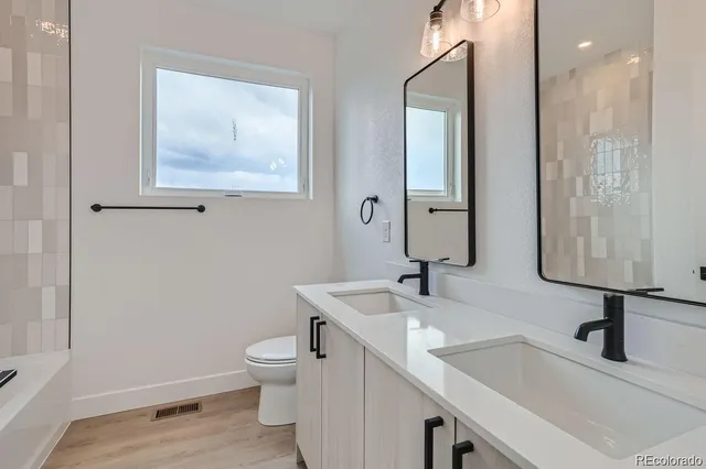 a bathroom with a toilet sink and mirror