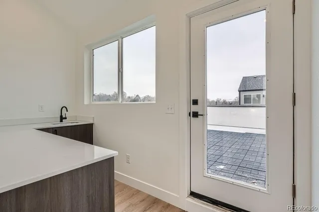 a view of a kitchen with a sink and wooden floor