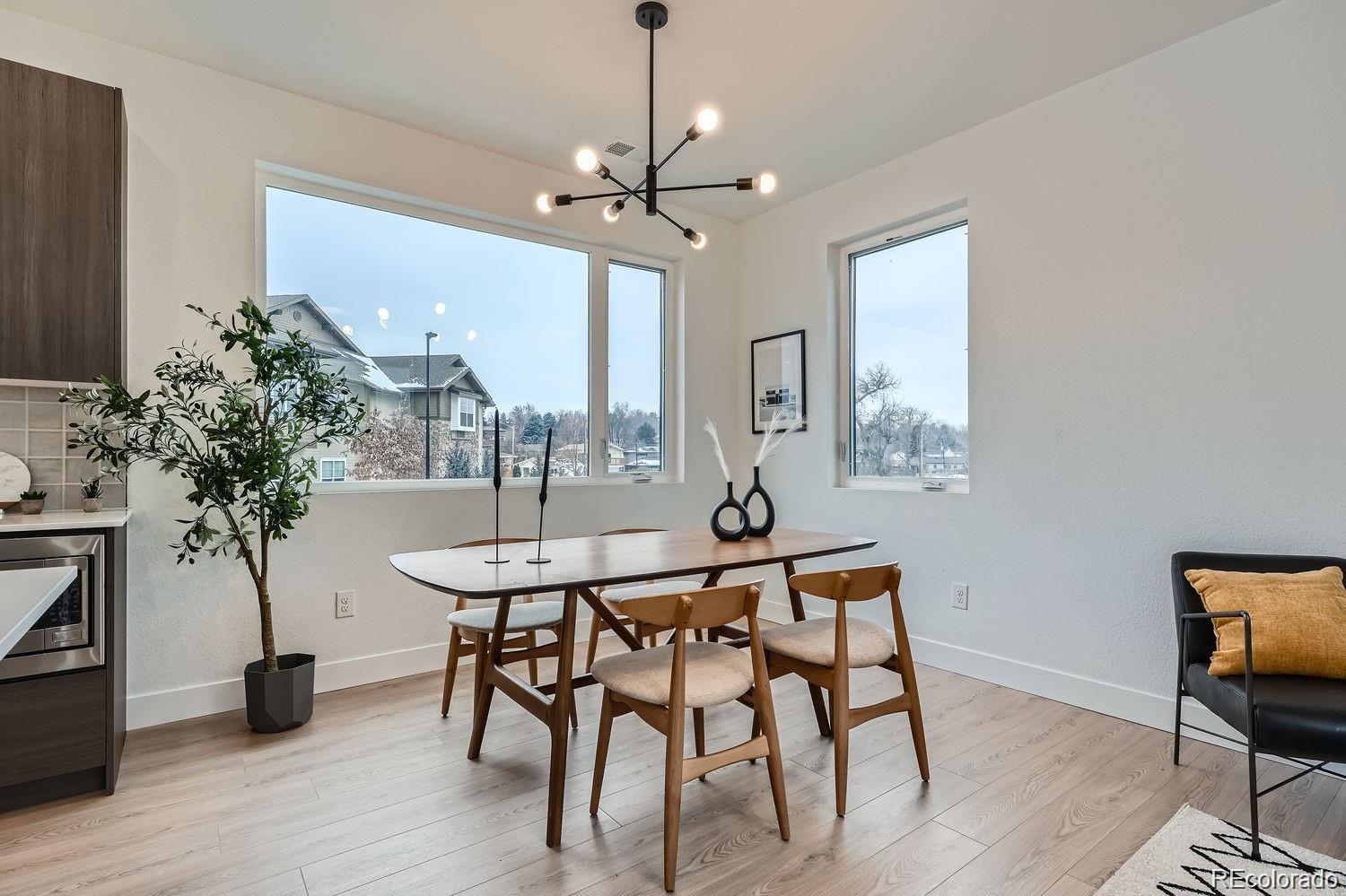 10187 West 38th Avenue Wheat Ridge, CO 80033 - Photo 9 of 50 a dining room with furniture a chandelier and wooden floor