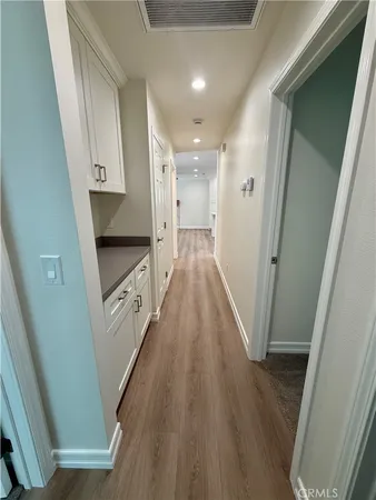 a view of a hallway with wooden floor and staircase