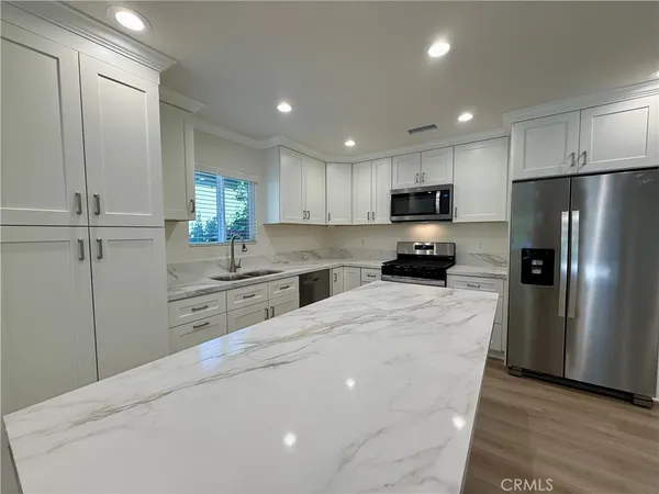 a kitchen with granite countertop a refrigerator and a sink