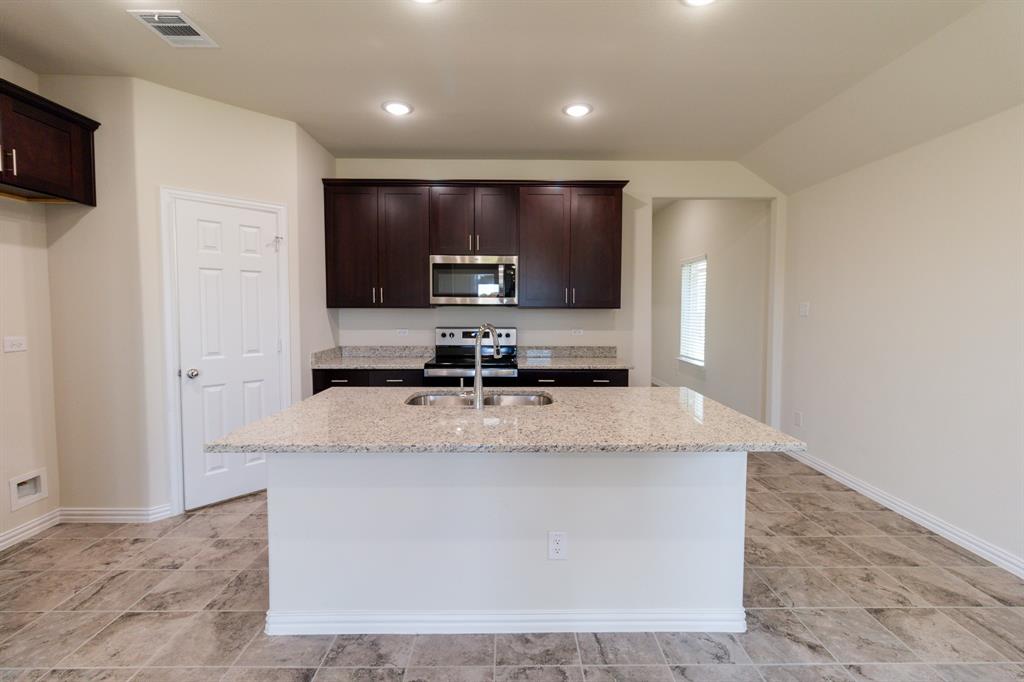 572 Ruthye Lane Pilot Point, TX 76258 - Photo 16 of 32 a large kitchen with stainless steel appliances a sink stove and refrigerator