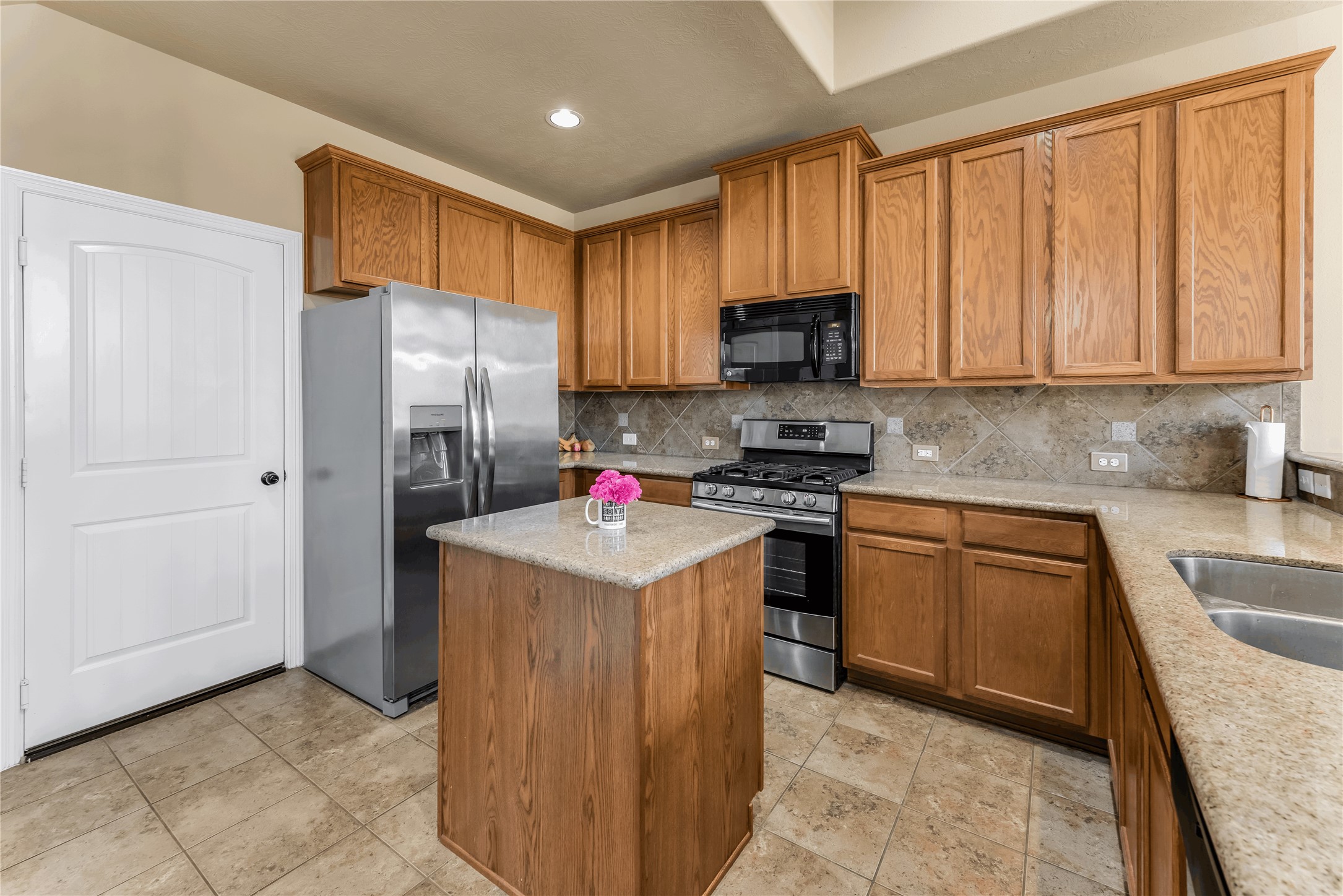 723 Audra Lane Spring, TX 77386 - Photo 11 of 35 a kitchen with stainless steel appliances granite countertop a refrigerator stove microwave and sink