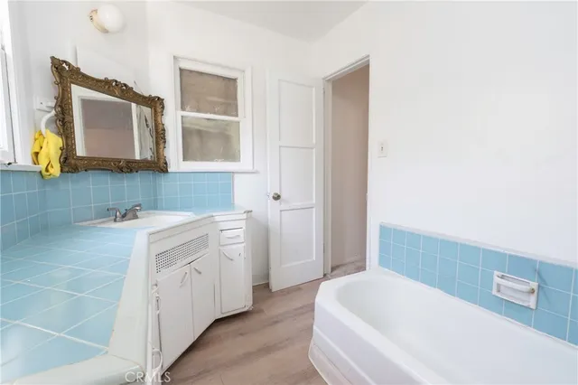 a spacious bathroom with a bathtub sink and mirror