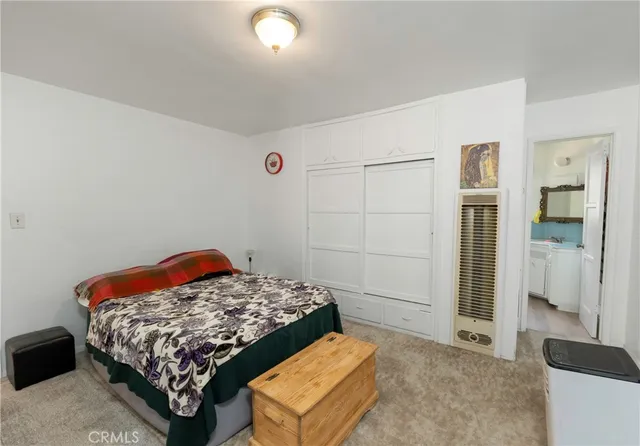 a bedroom with a bed and cabinet