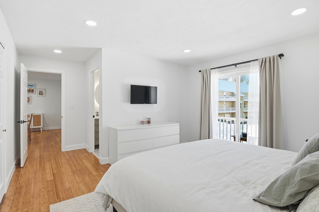 425 Main Street, Unit 21D Hudson, MA 01749 - Photo 15 of 21 a bedroom with a bed and a flat tv screen in it