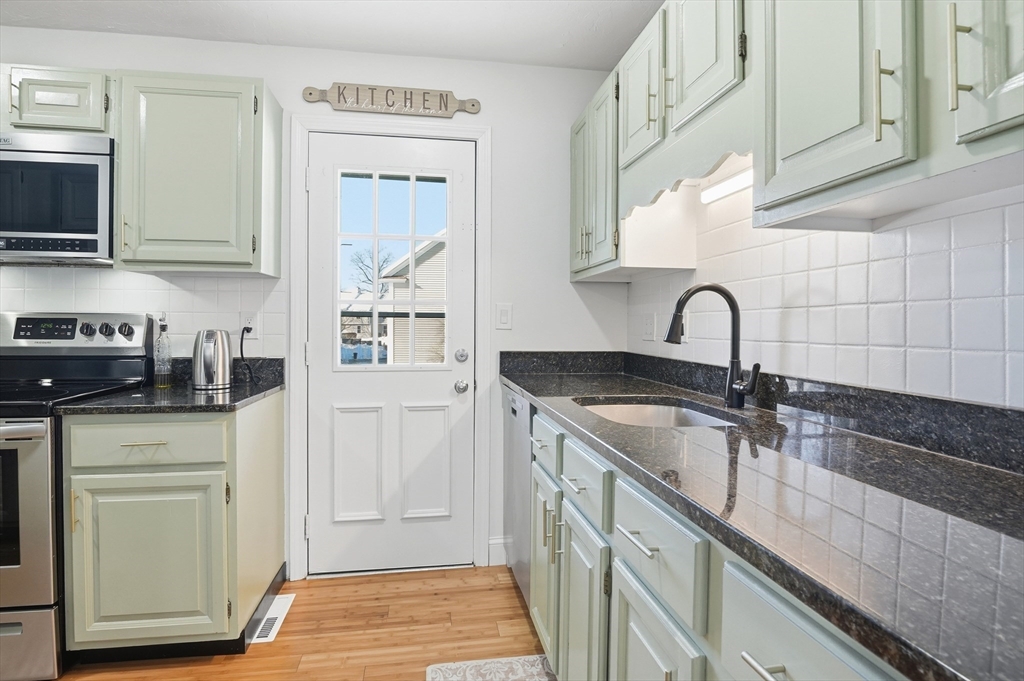 425 Main Street, Unit 21D Hudson, MA 01749 - Photo 6 of 21 a kitchen with stainless steel appliances granite countertop a sink and a stove