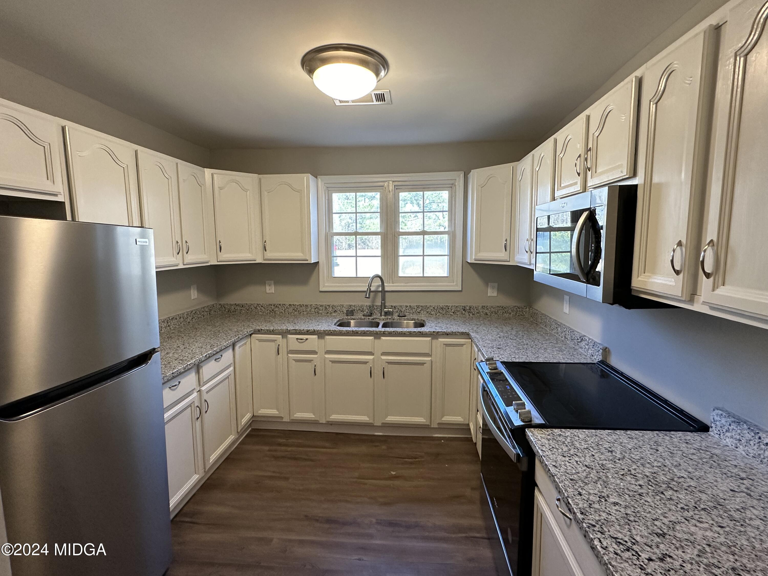 365 Taylor Road Juliette, GA 31046 - Photo 4 of 12 a kitchen with stainless steel appliances granite countertop a stove a sink and a refrigerator