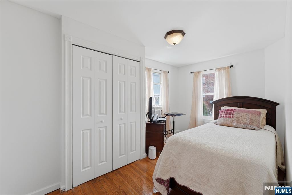 385 Berkeley Avenue Bloomfield, NJ 07003 - Photo 18 of 39 a bedroom with a bed and a chandelier