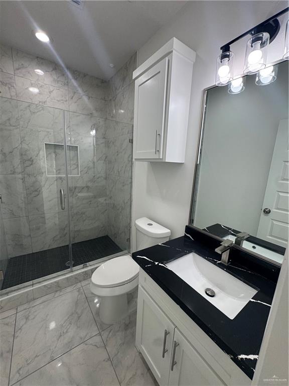 2109 Dragonfly St Mission, Unit 2 Mission, TX 78572 - Photo 12 of 16 a bathroom with a granite countertop sink toilet and shower