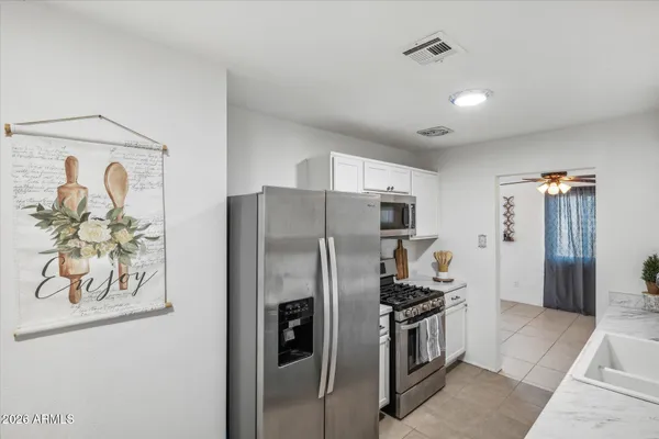 a kitchen with stainless steel appliances granite countertop a refrigerator and a stove