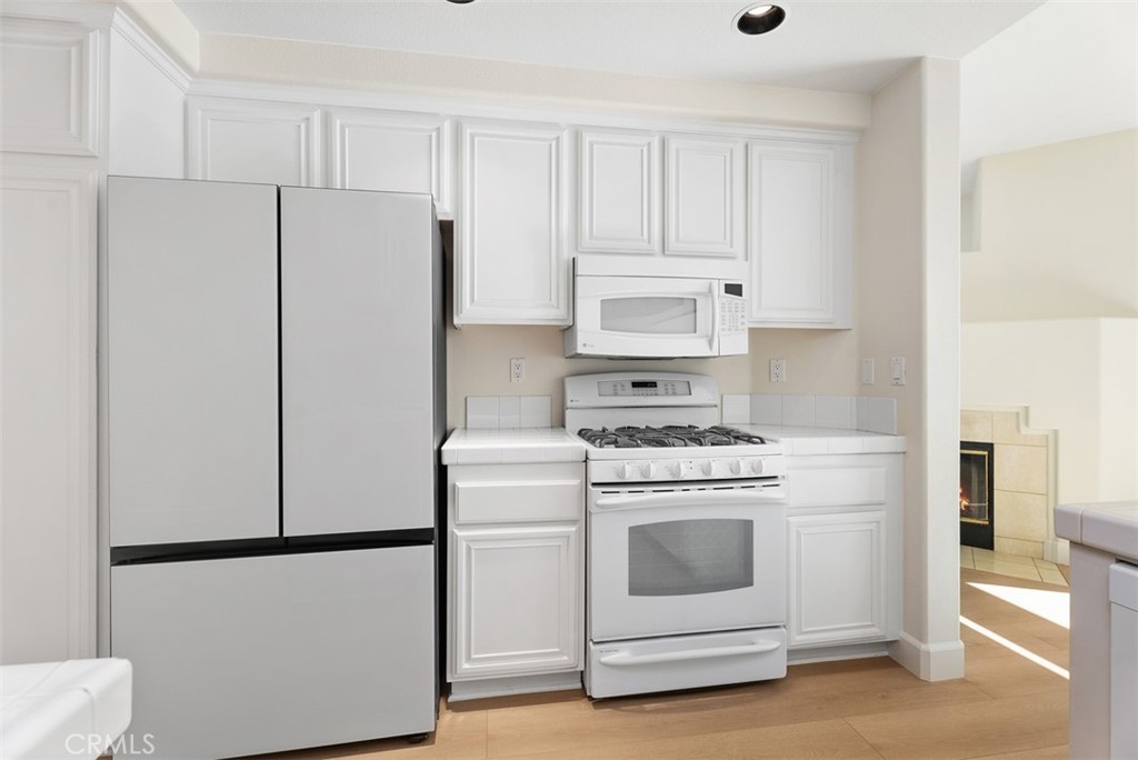 6 Stoney Pointe Laguna Niguel, CA 92677 - Photo 12 of 37 a kitchen with cabinets and white stainless steel appliances