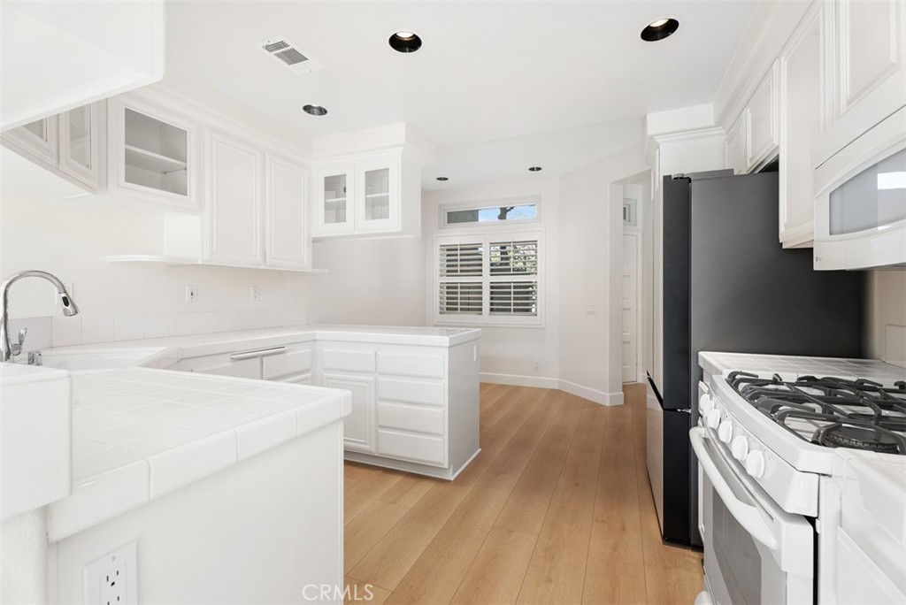 6 Stoney Pointe Laguna Niguel, CA 92677 - Photo 13 of 37 a kitchen with white cabinets and appliances