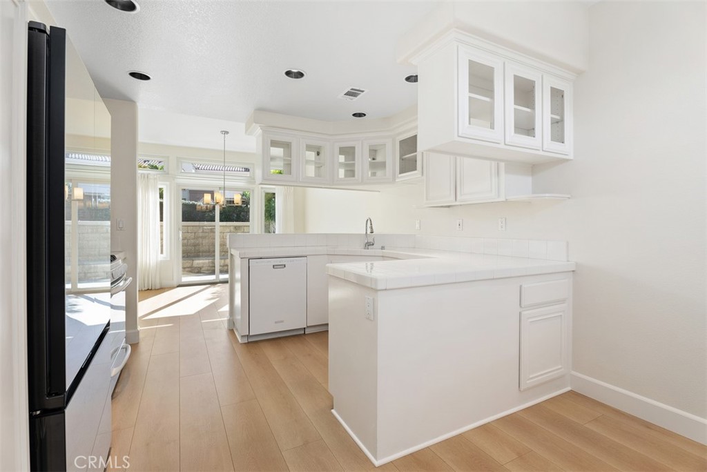 6 Stoney Pointe Laguna Niguel, CA 92677 - Photo 9 of 37 a kitchen with cabinets and wooden floor