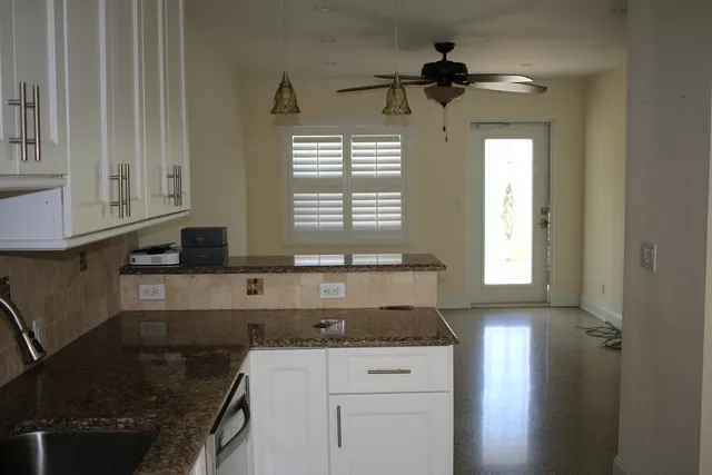 a kitchen with granite countertop a sink and a stove