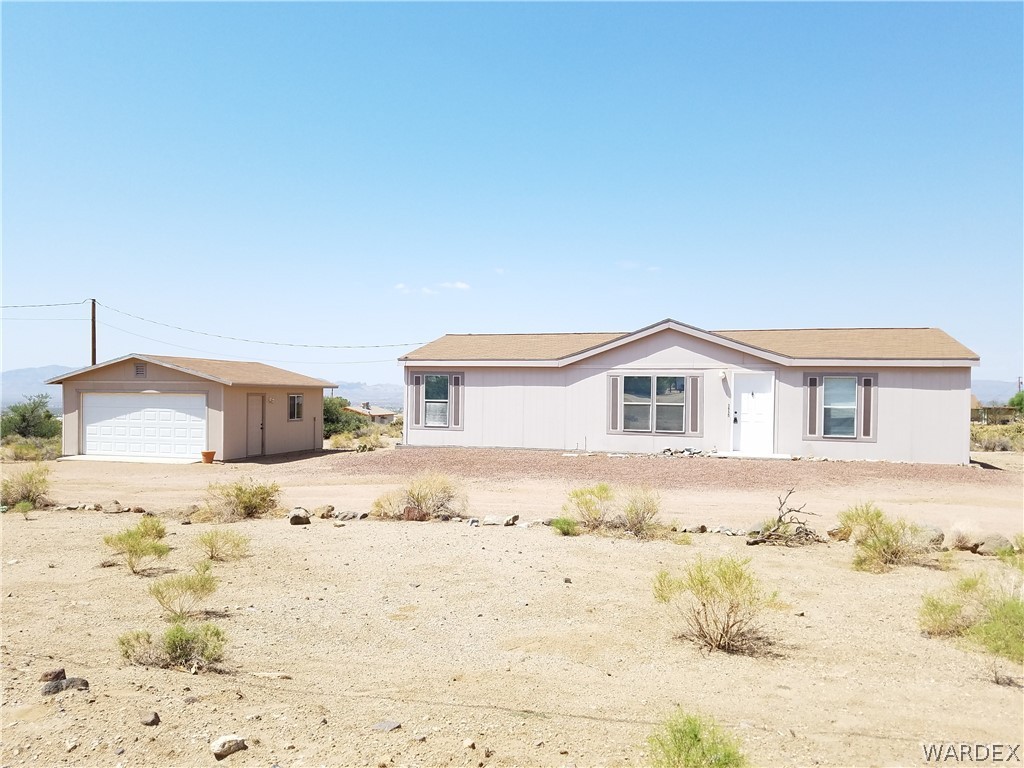 3955 Bosque Road Golden Valley, AZ 86413 - Photo 1 of 27 a yellow and white house with a outdoor space