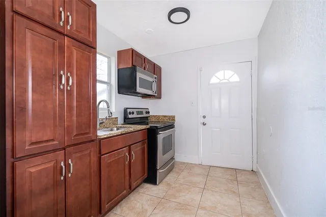 a kitchen with stainless steel appliances granite countertop a refrigerator and a microwave