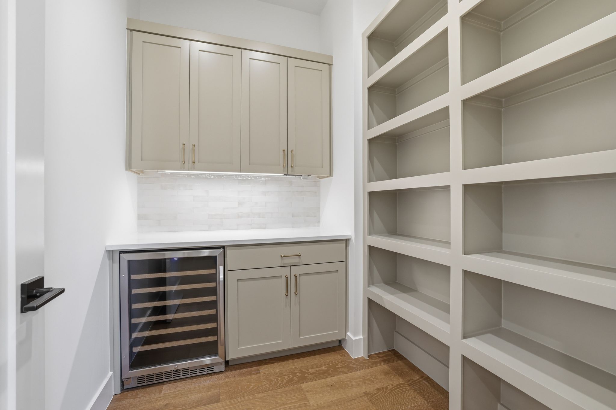 4500 Jinx Avenue Austin, TX 78745 - Photo 33 of 40 Bar featuring beverage cooler, light wood finished floors, backsplash, gray cabinetry, and light stone countertops