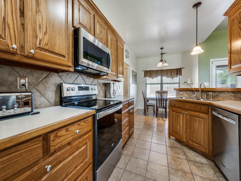 100 County Road 4181 Decatur, TX 76234 - Photo 13 of 35 a kitchen with stainless steel appliances granite countertop a sink a stove and cabinets