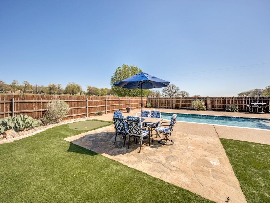 100 County Road 4181 Decatur, TX 76234 - Photo 32 of 35 a view of a swimming pool with a table and chairs under an umbrella