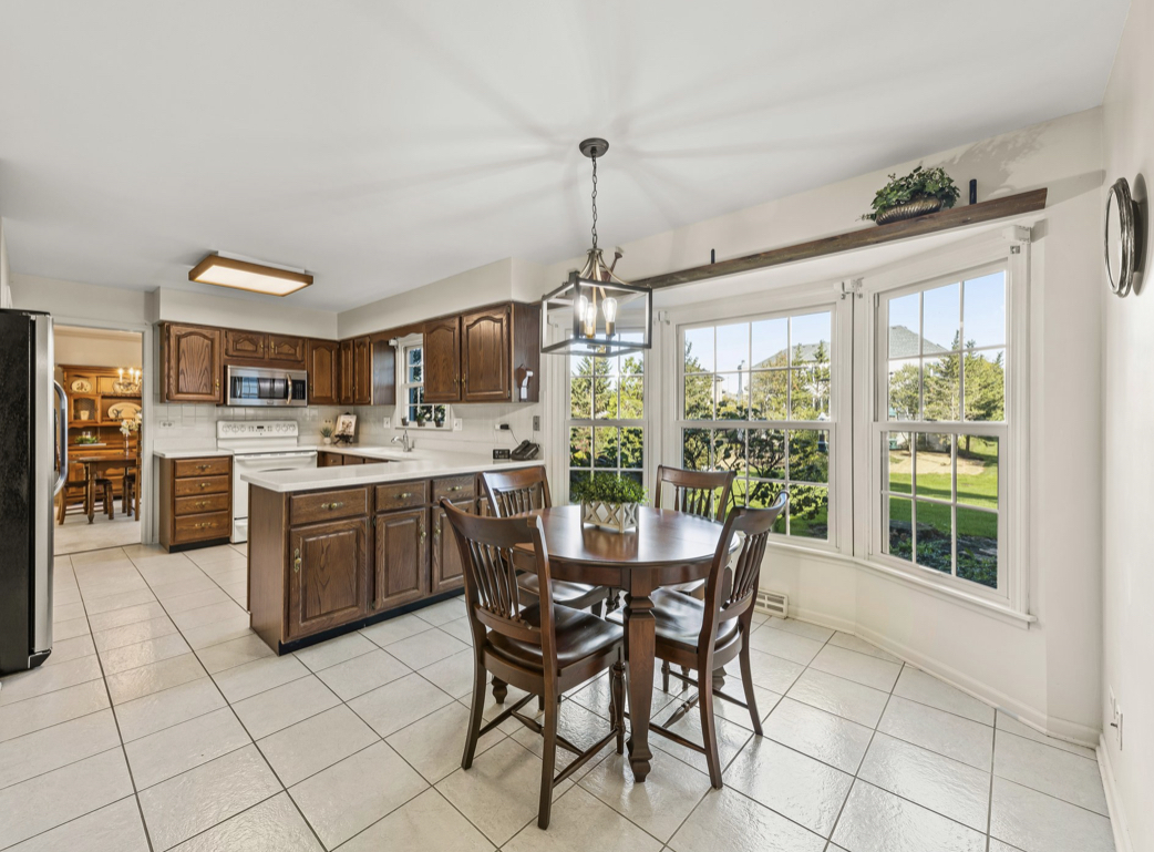 1580 Clemson Drive Naperville, IL 60565 - Photo 9 of 34 a kitchen with stainless steel appliances granite countertop a stove and a chandelier