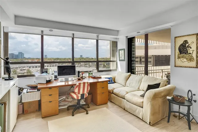 a view of a livingroom with workspace and a large window