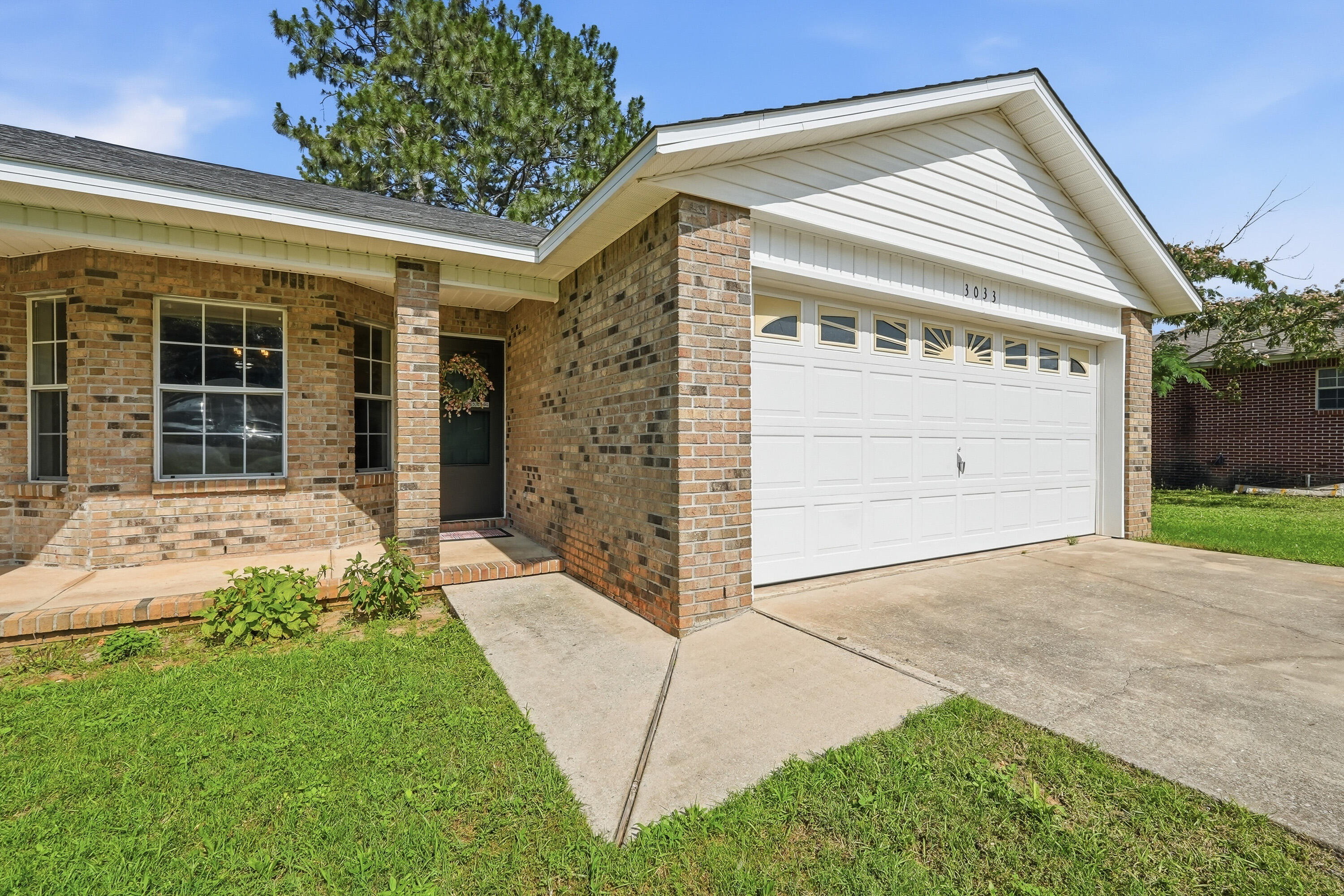 3033 Cabela Lane Crestview, FL 32539 - Photo 27 of 32 a front view of a building with a garden and entryway