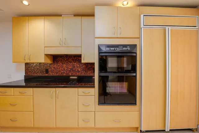 a kitchen with granite countertop white cabinets and stainless steel appliances