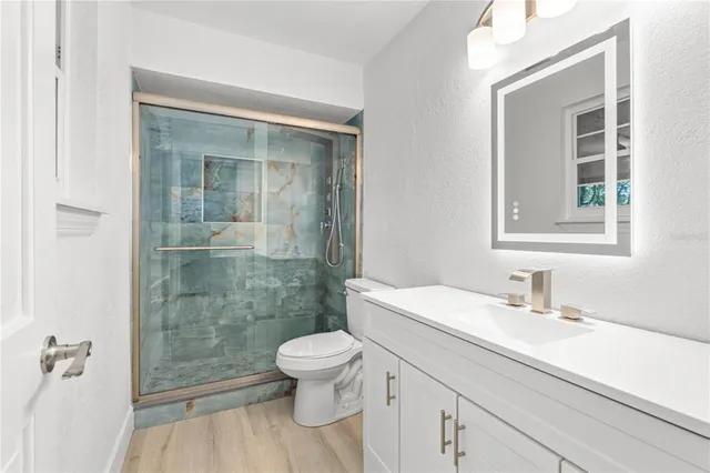 a bathroom with a sink a toilet and shower