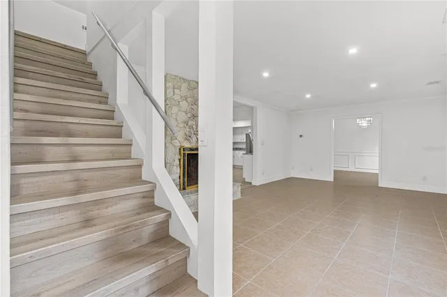 an empty room with wooden floor ceiling fan and window