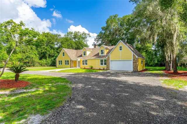 a view of a house with a yard and a garage
