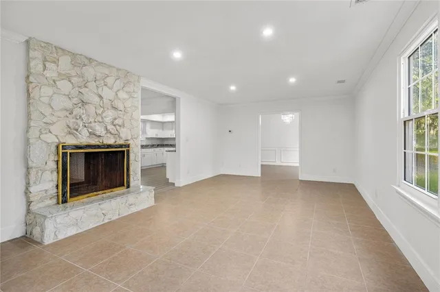 an empty room with windows and fireplace