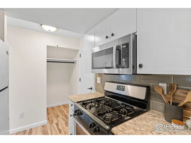 a kitchen with stainless steel appliances granite countertop a stove a microwave and a refrigerator