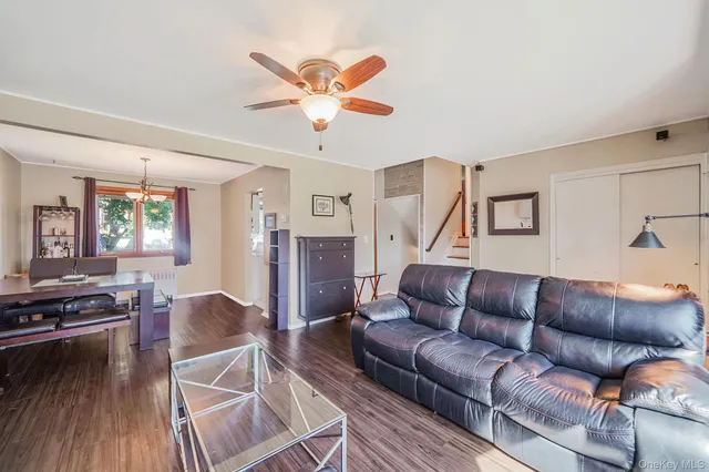 a living room with furniture and a flat screen tv with wooden floor