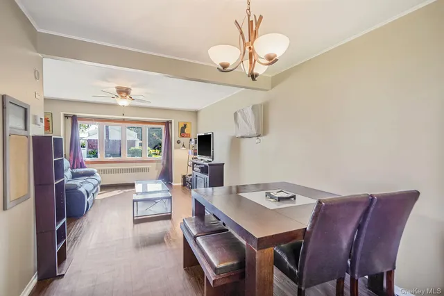 a view of a dining room with furniture a chandelier and wooden floor
