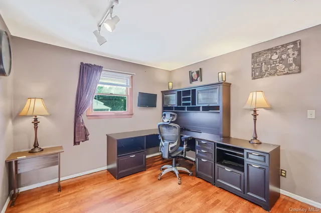 a view of a workspace with furniture and a window