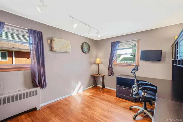 a view of a workspace with furniture and a window
