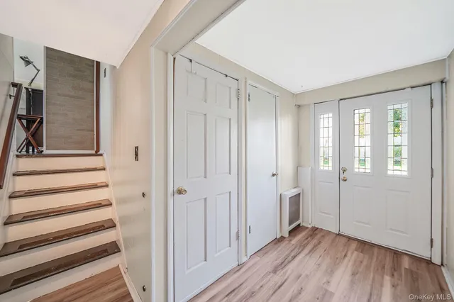 a view of a hallway with wooden floor and entryway