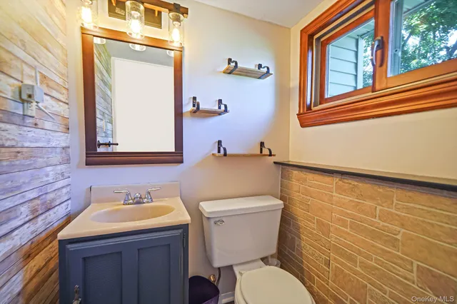 a bathroom with a granite countertop toilet sink and mirror