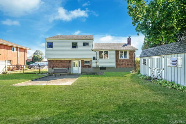 a front view of a house with a yard and trees