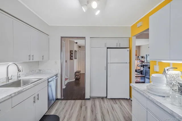 a kitchen with a sink a refrigerator and wooden floor