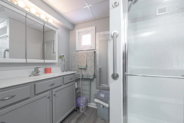 a bathroom with a shower sink and mirror