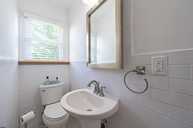 a bathroom with a sink a toilet and a mirror