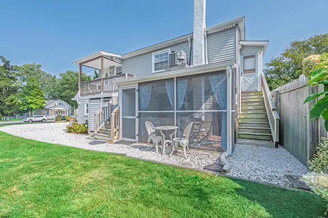 a view of a chair and table in backyard of the house