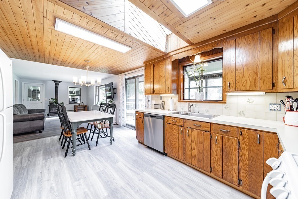 11 Clark Wright Road Middlefield, MA 01011 - Photo 12 of 30 a dining hall with stainless steel appliances granite countertop a stove a sink dishwasher a dining table and chairs with wooden floor