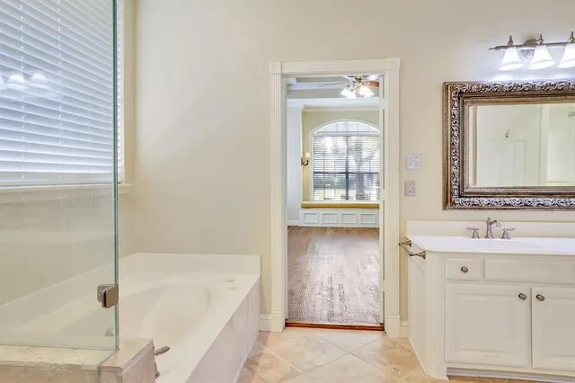 a bathroom with a tub sink and mirror