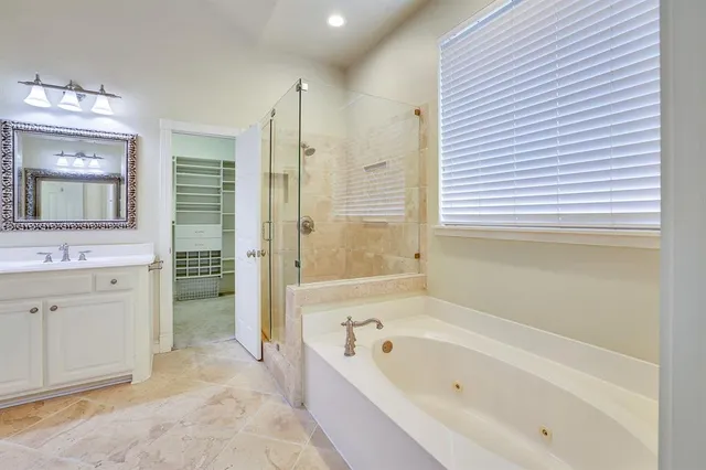 a bathroom with a bathtub a mirror a shower and vanity