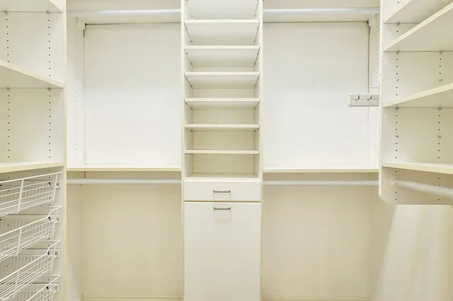 a view of walk in closet with empty racks